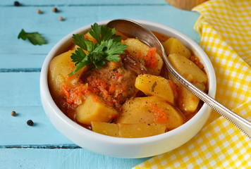 Homemade stew with meat and vegetables on a black background