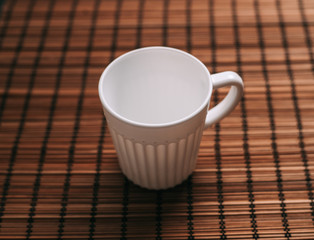 A light cup on a wooden napkin