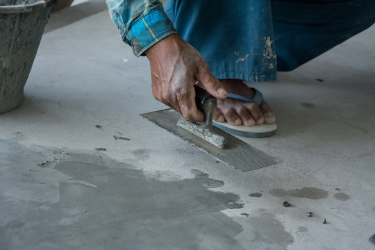 plasterer concrete worker at floor of house construction