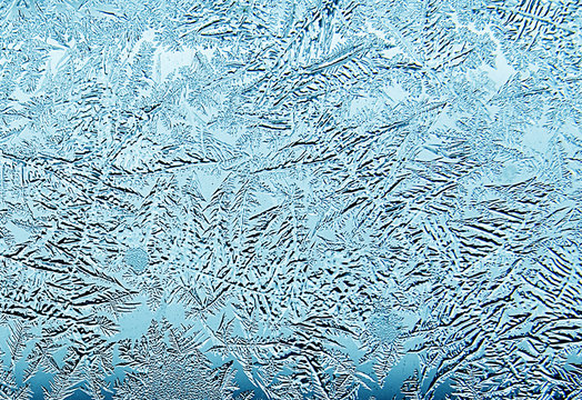 Frosty natural pattern on winter window.Frost patterns on glass.Winter ice embroidered lace on the window.