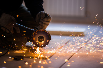 Cutting metal with angle grinder. - Powered by Adobe