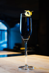 Alcohol coctail drink with lemon on the table in bar restaurant. Made from classic English gin, london dry  blue dark syrup.