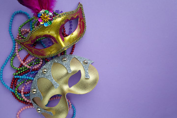 Festive, colorful group of mardi gras or carnivale mask on purple background.
