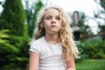 Close-up portrait of thoughtful little girl with long blond hair