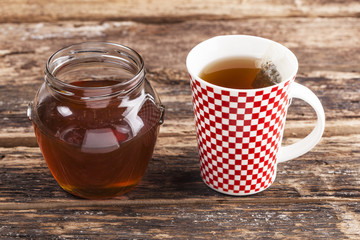 Cup of tea with honey on wooden table