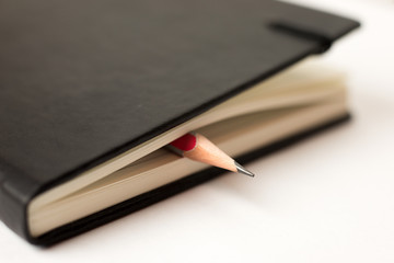 Pencil on the pages of an closed notebook for records