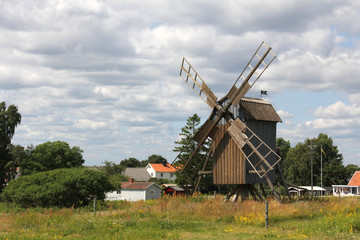 Fototapeta na wymiar Old wooden windmill in the trees