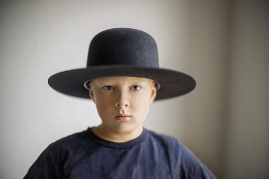 Portrait of a young boy wearing a bowler hat.
