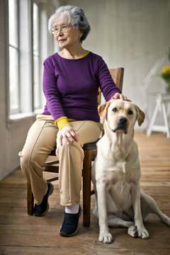 Senior woman sitting with her dog at a doctor's office.
