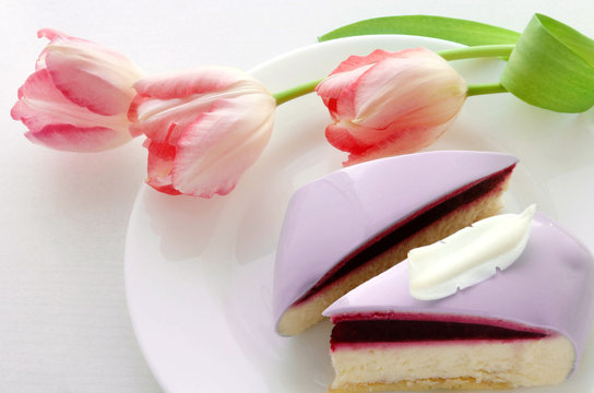 Two slices of mousse Cake and pink Tulips. Valentine's Day. Romantic Dessert.