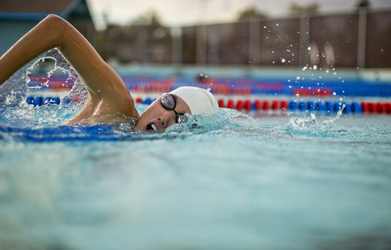 Young woman swimming the front crawl in a pool.