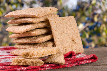 stack of crisp bread on a wooden table with blurred garden background