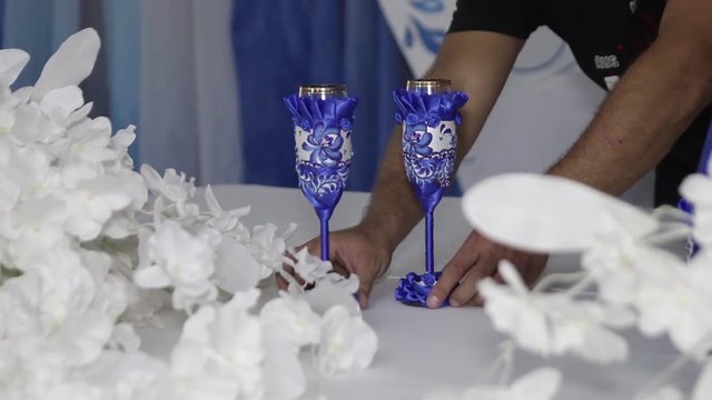 Декоратор ставит два фужера на стол