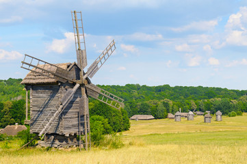 Fototapeta na wymiar old wooden windmill in a field