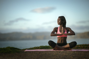 Young woman doing yoga on beach