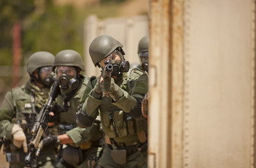 Group of police officers about to enter a building during an exercise at a training facility.