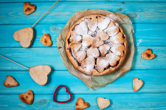 Idea for the celebration of Valentine's Day: cherry pie with the decor  the dough in the shape  heart on wooden table.