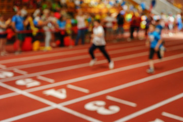 Blurred image of children athletes on a racetrack during finishing. 