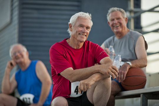 Portrait of three happy senior men relaxing after playing basketball