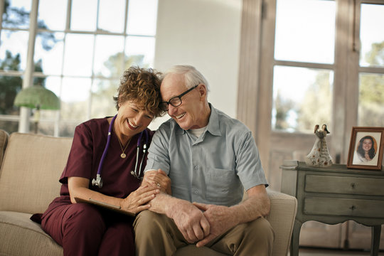 Smiling mature nurse comforting an elderly patient.