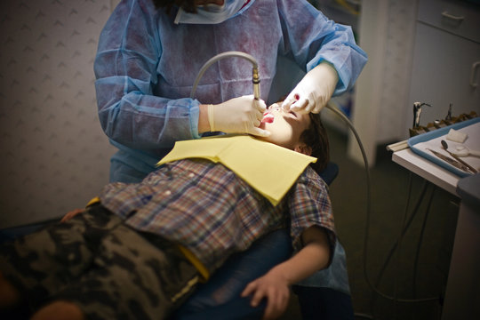 High angle view of a young boy being examined by a dentist.