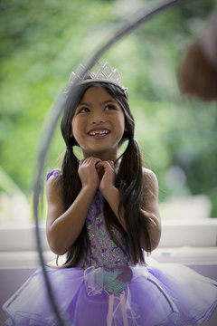 Happy young girl wearing a tiara and a tutu.