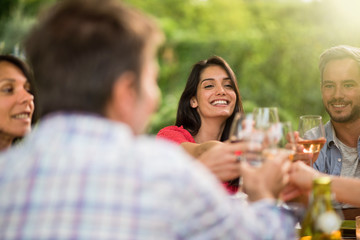 Group of friends toasting during a party on a terrace in summer