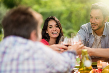 Group of friends toasting during a party on a terrace in summer