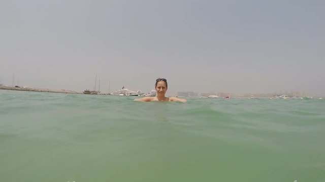 The girl is bathed in the sea and sprinkles water. Slow motion shooting.