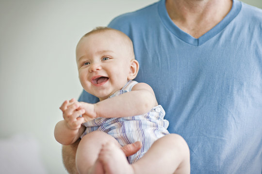Smiling baby in father's arms