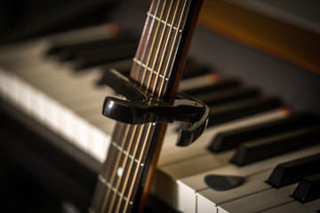 musical instruments piano keys and acoustic guitar capadaster
