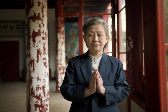 Senior woman praying in temple