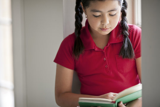 Close up of schoolgirl reading a book