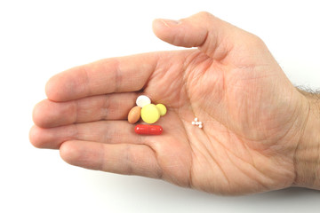 Hand mit Tabletten und Globuli
