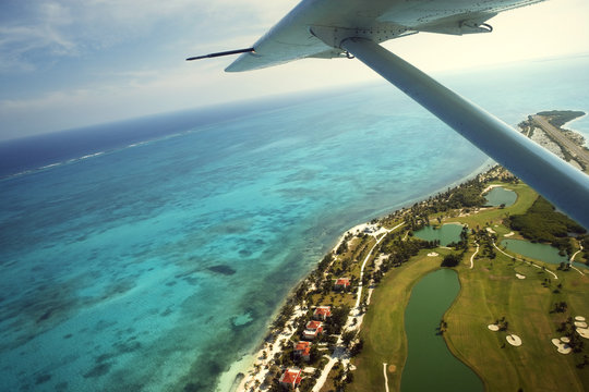 Plane flying over a tropical island.