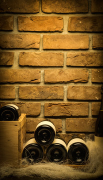 Stos butelek wina w piwnicy. Stock Photo | Adobe Stock