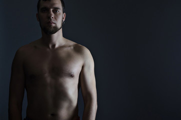 Fototapeta na wymiar Athletic man with a bare-chested on a black background.