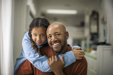 Portrait of father and daughter at home.