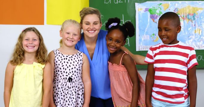 Portrait of teacher and kids smiling in classroom at school 4k