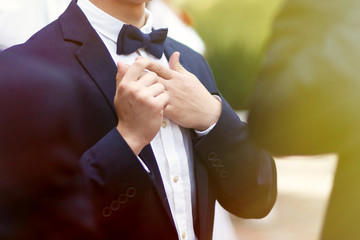 stylish confident man in suit and bowtie, reception at luxury we