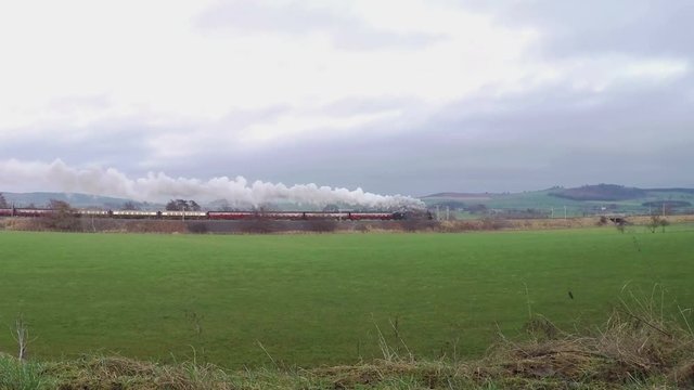 English Steam Train.  A steam train heads across the Cumbrian countryside in northern England, on the English west coast mainline (4k, 25fps).