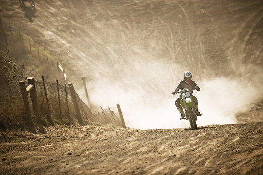 Motorbike racer racing through a dirt road