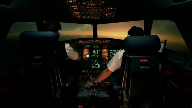 Beautiful view trough windscreen or windshield front window of modern airplane Airbus A319 A320 A321 at the sunset. Aircrew in in the cockpit or flight deck. Shot at training center