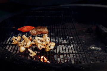 vegetables and meat grilling.  beefsteak mushrooms  tomatos garl