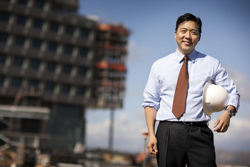 Portrait of engineer with hardhat standing at construction site