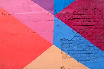 Photo sur Aluminium Graffiti Mur de briques colorées avec du violet, du bleu, du rose et du beige comme texture de fond