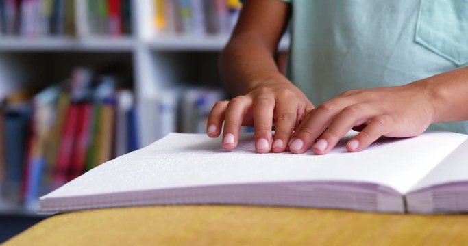 Slow motion of school kid reading a braille book in classroom at school 4k