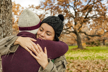 Portrait young couple hugging in an autumn background. Back view