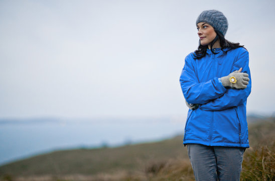 Young woman wearing warm clothing while out in the country.