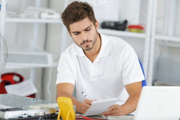 young engineer taking notes while developping new induction hobs
